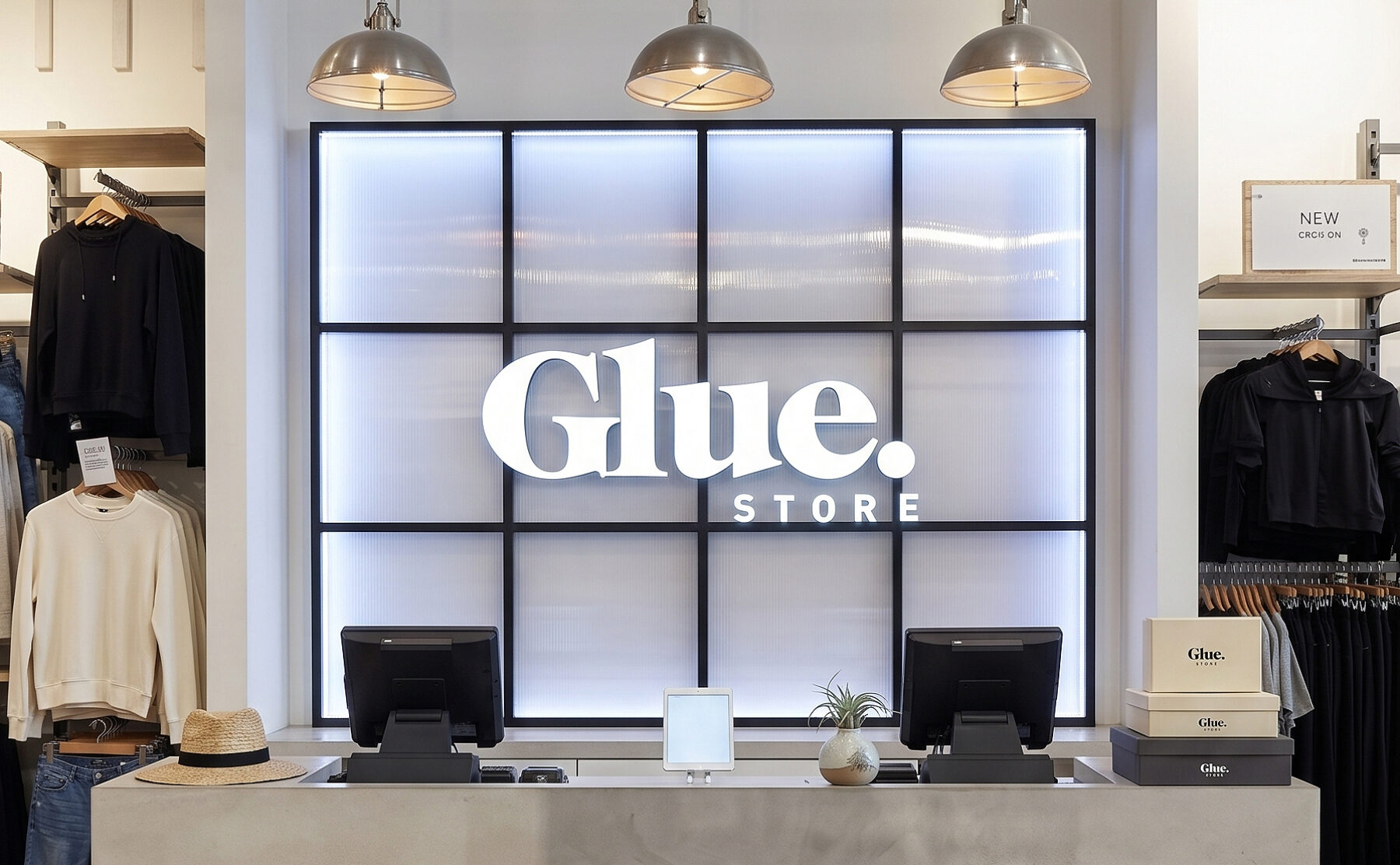 A concrete-rendered point of sale desk set against an illuminated grid wall panel.