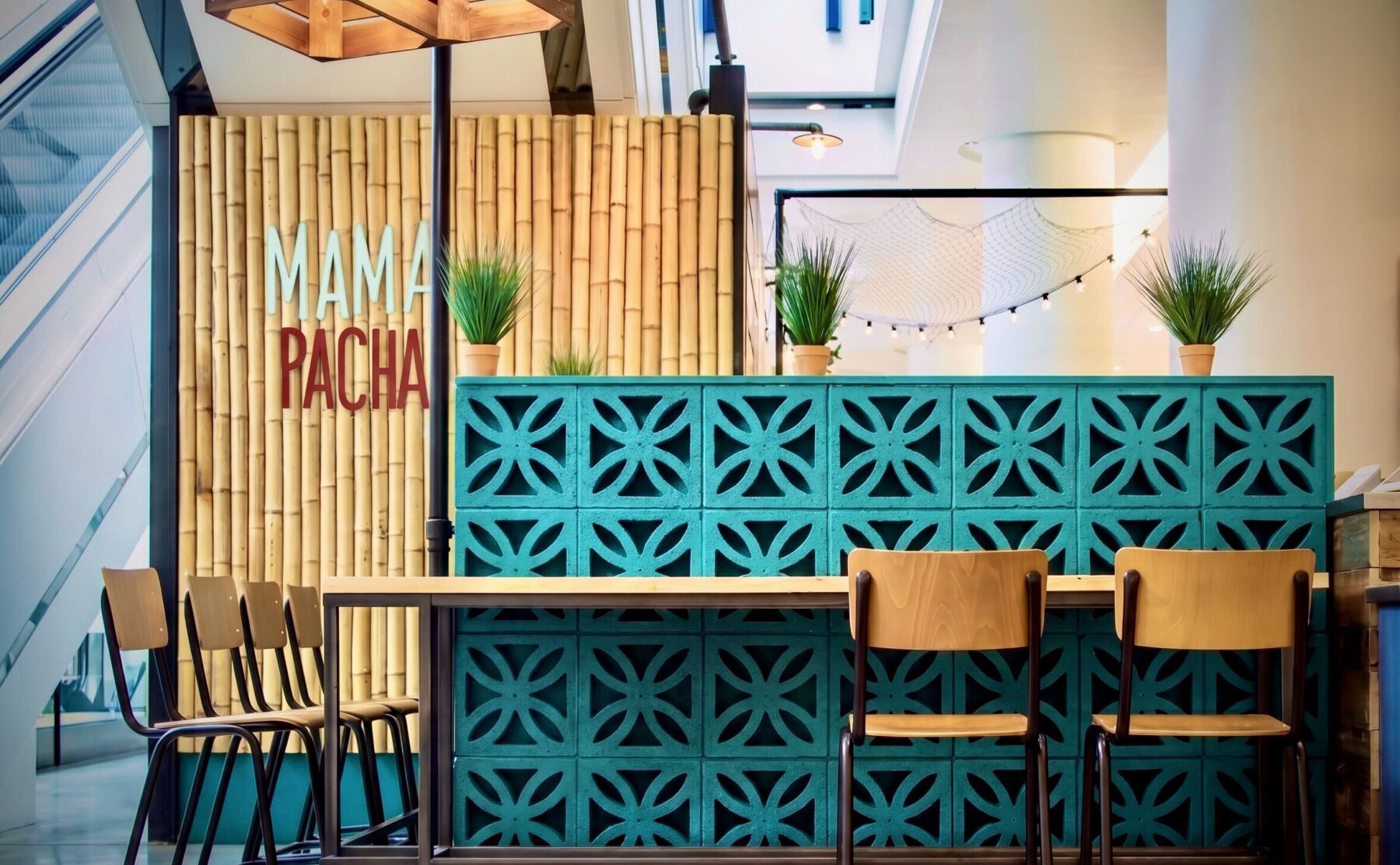 Breeze block screen wall, turquoise concrete blocks, bamboo wall cladding, custom timber pendant, industrial bar stools, commercial cafe zoning, architectural screening, high topped dining table.