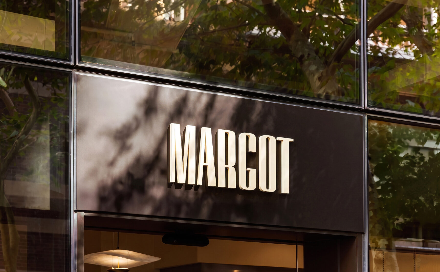 Margot Osteria’s entrance offers a first glimpse into the experience that awaits inside. Bold signage and grand windows give the space a confident presence, while warm lighting and accents of the signature Margot terracotta create a sense of character and charm.