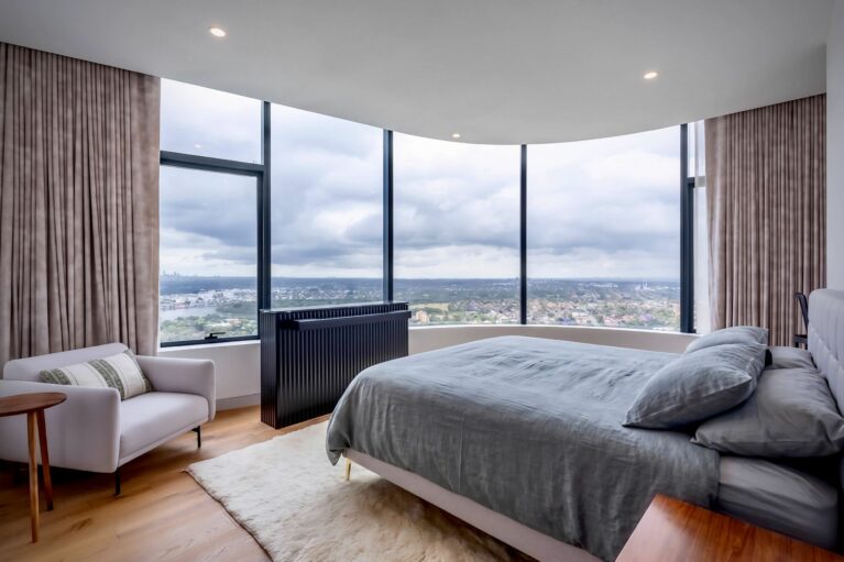 The master bedroom offers a serene retreat with expansive views, floor-to-ceiling windows, and luxurious furnishings. 