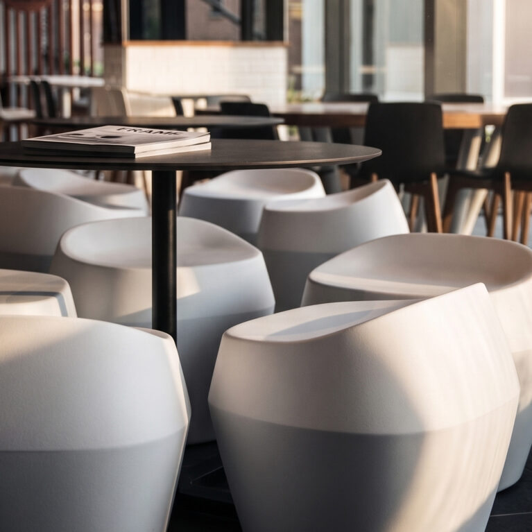 Commercial food court, molded composite stools, circular café tables, timber dining chairs, angular spatial layout, commercial floor tiles, community hub seating.
