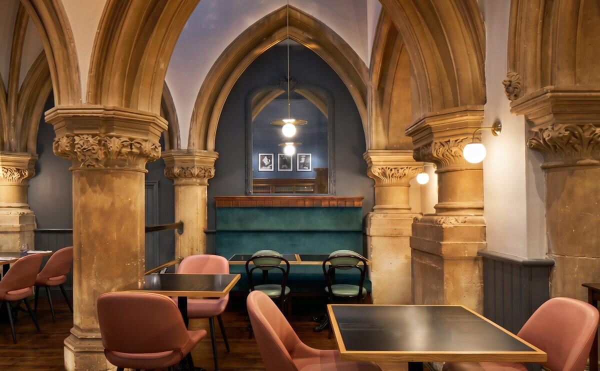 Intimate dining alcoves framed by historical stone colonnades.