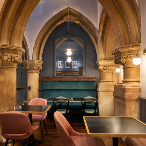 Intimate dining alcoves framed by historical stone colonnades.