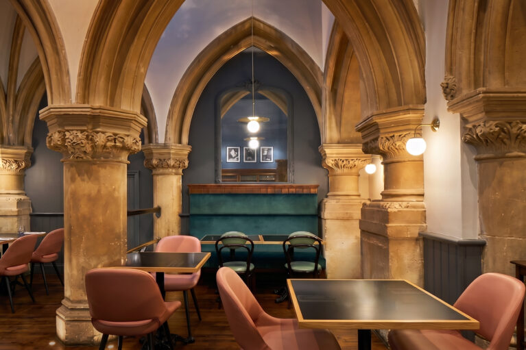 Intimate dining alcoves framed by historical stone colonnades.