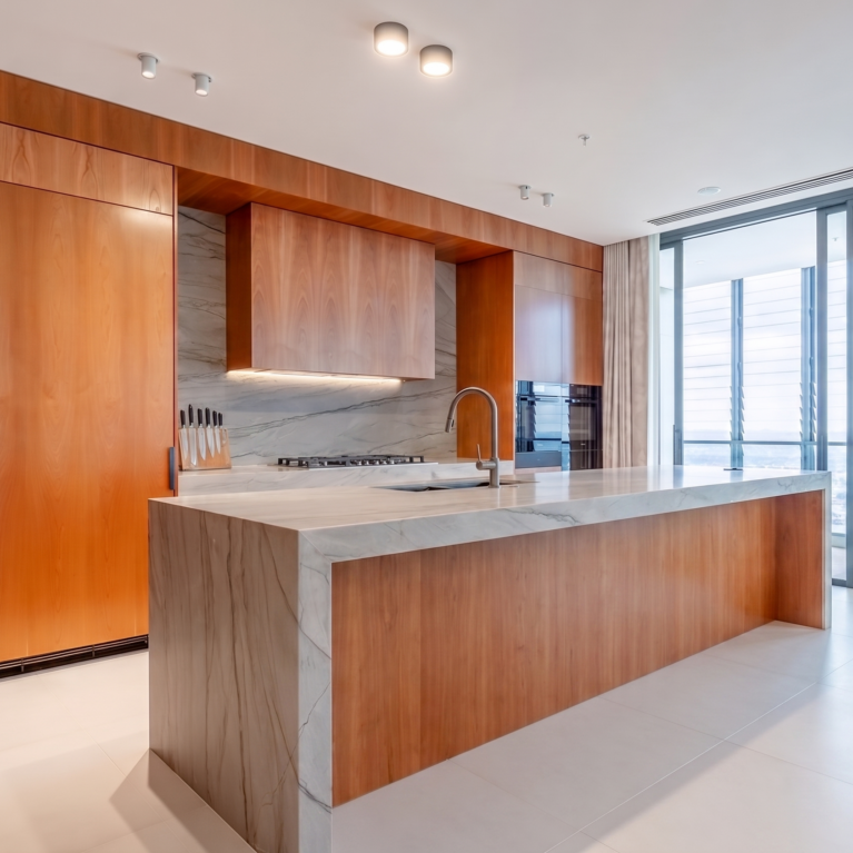 The generous kitchen island features an expansive Quartzite countertop and comfortable leather upholstered bar stools, creating a perfect space for dining and gatherings. Added extras include a pop-up GPO tower for family device charging.