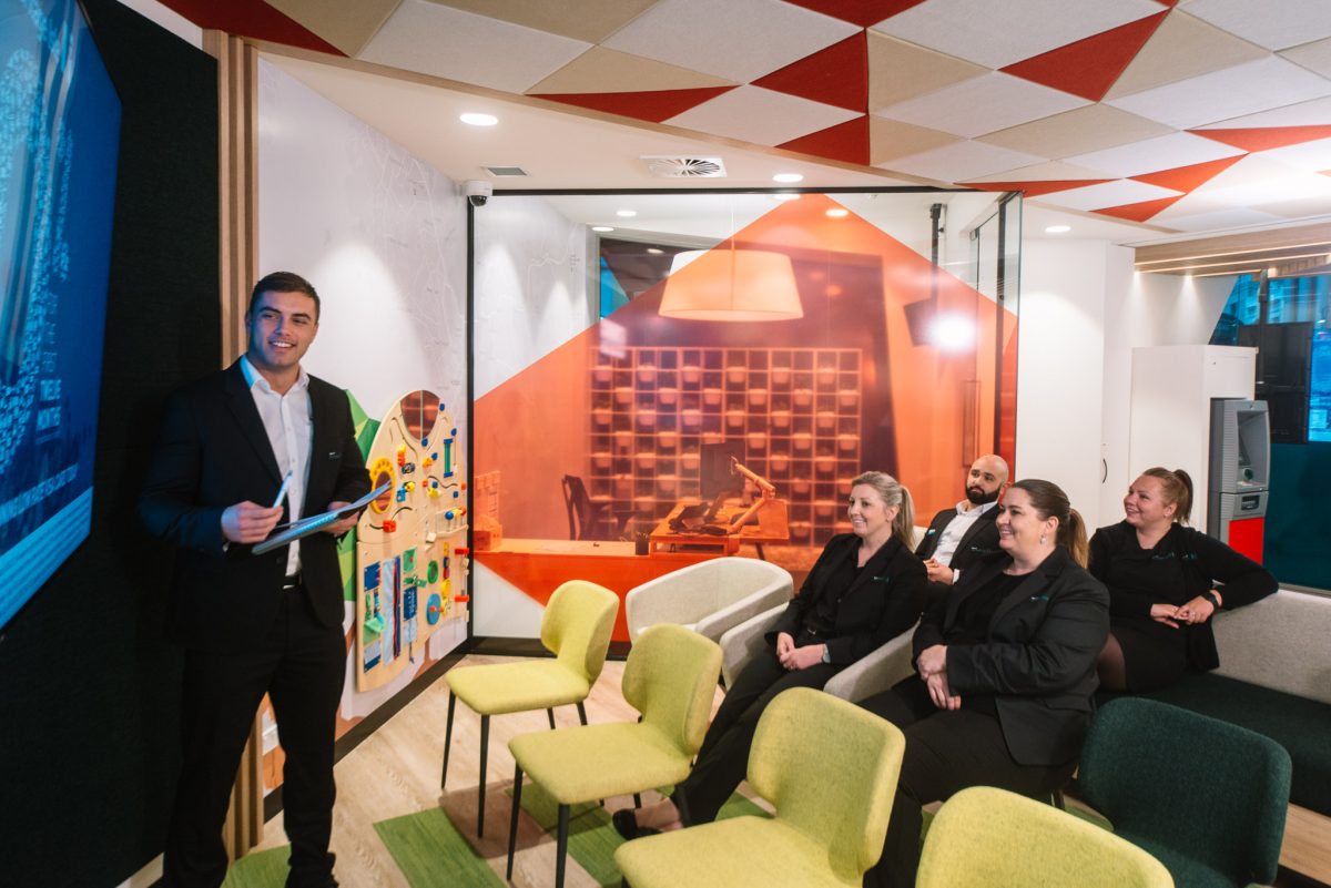 Heritage Bank’s flexible meeting area, designed for presentations and seminars, with a modern, casual setup featuring an interactive screen and colorful seating.