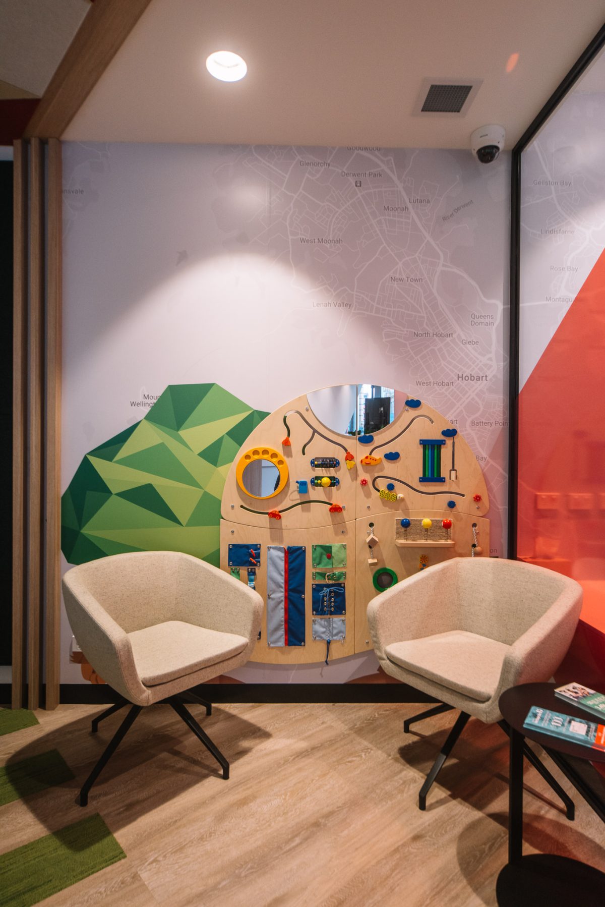 A playful and inviting children’s zone, designed with interactive wall panels, cozy seating, and soft pastel colors to engage young visitors.