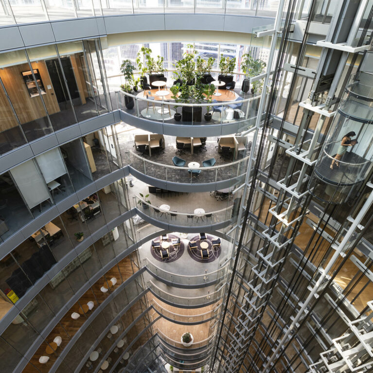 A cascading atrium of collaborative terraces, soft lounge areas, and planting, forming a transparent living spine that connects multiple levels and supports focused work, casual meetings and moments of rest.