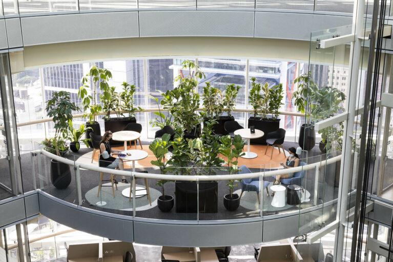 Intimate balcony pods float above the city, softened by circular rugs, lush greenery and light-filled glass-steel edges, designed as overflow sanctuaries for informal gatherings or quiet solo retreat.
