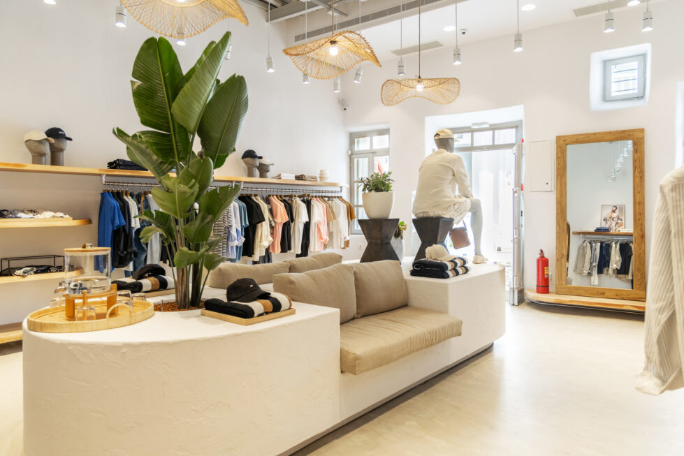 A seamless fusion of organic textures and refined minimalism, this retail space features sculptural seating, curated greenery, and light wooden shelving, creating a warm yet sophisticated shopping experience.