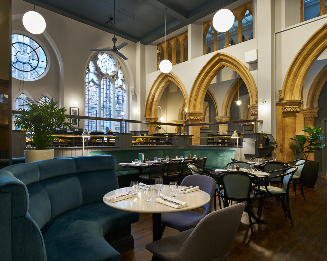 High-volume dining space integrated within a soaring heritage interior.