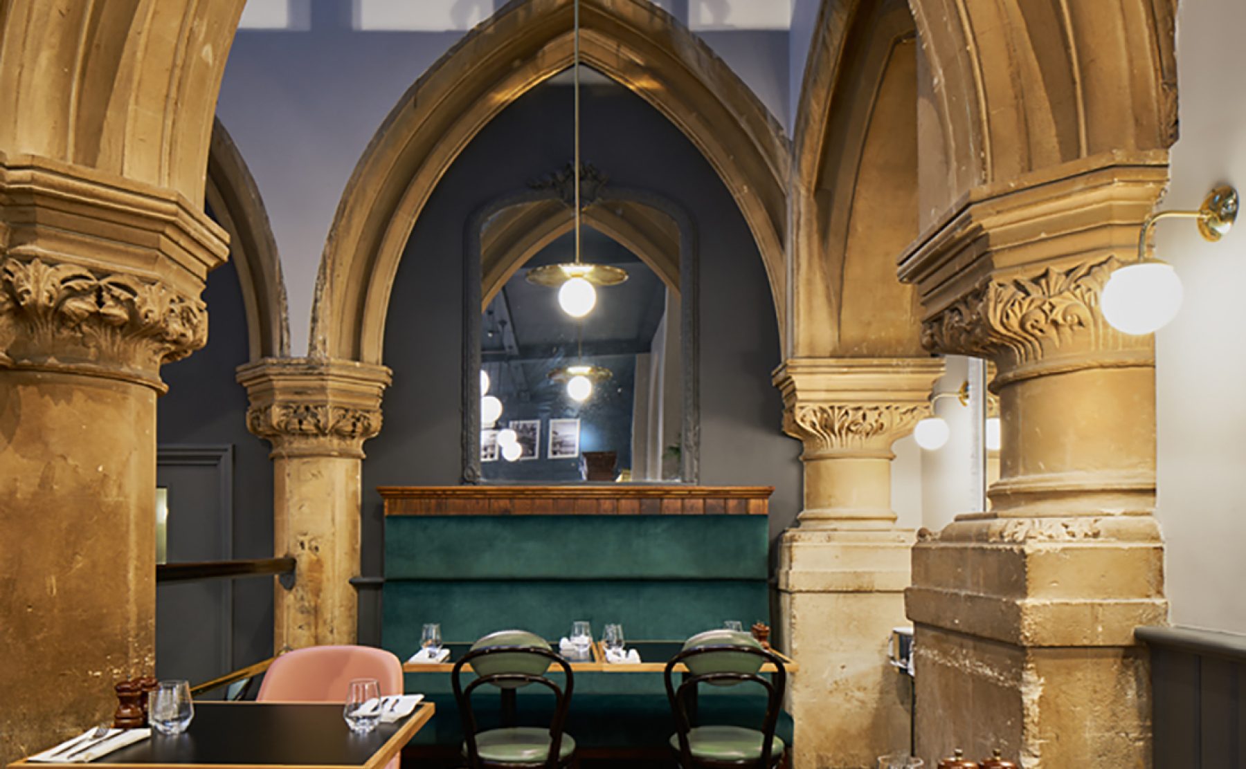 Intimate dining alcoves framed by historical stone colonnades.