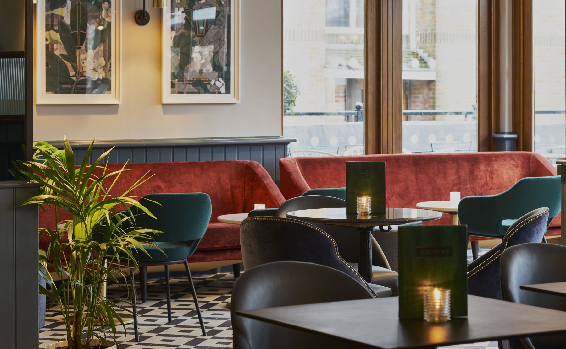A low-level lounge layout showcasing patterned tiling and rich velvet banquettes.