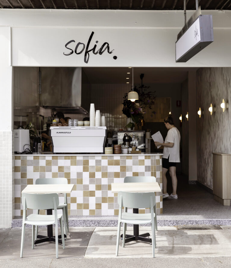 Sofia’s open façade features soft earthy tones and textured tiles, creating a warm and inviting first impression. The minimal “Sophia” logo complements the modern design, while fresh flowers and pastel seating add a welcoming touch.