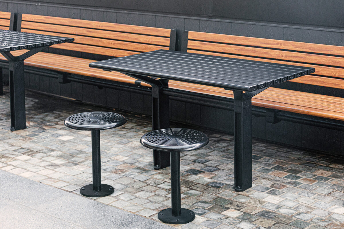 Timber slat bench, perforated steel stools, custom metal tables, dark wainscoting, cobblestone flooring, alfresco dining furniture, streetscape design, commercial precinct fitout, Sydney retail.