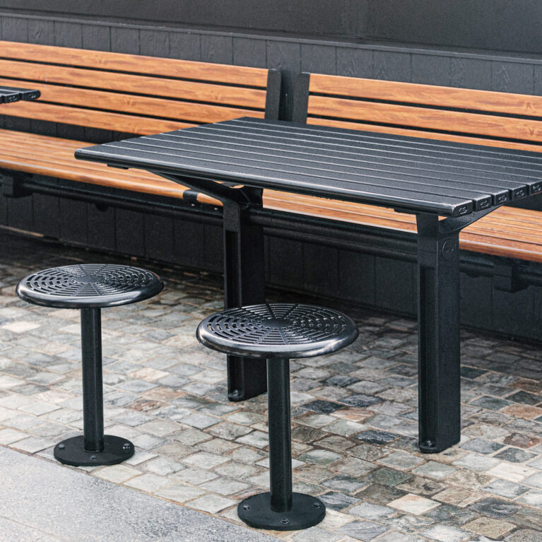 Timber slat bench, perforated steel stools, custom metal tables, dark wainscoting, cobblestone flooring, alfresco dining furniture, streetscape design, commercial precinct fitout, Sydney retail.