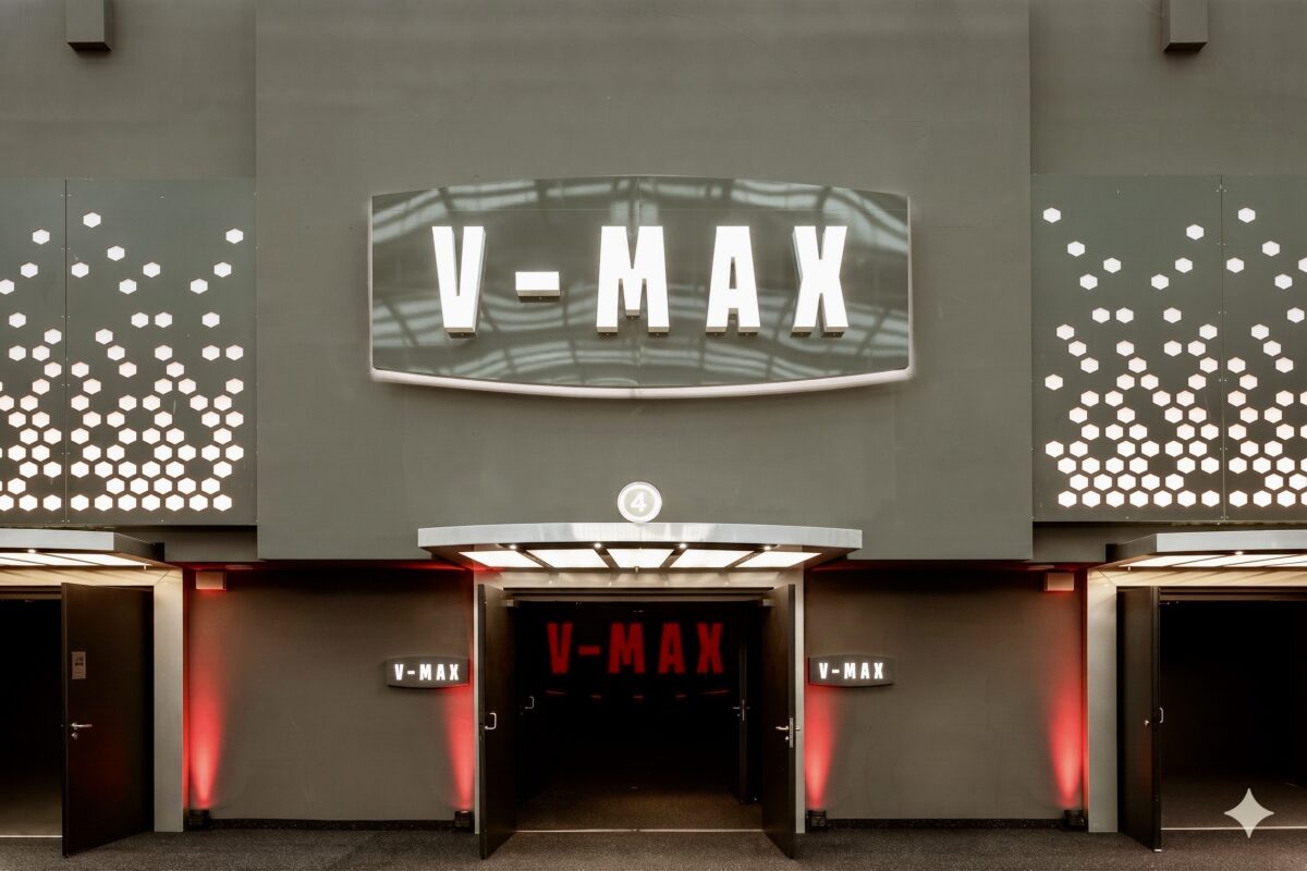 Auditorium entrance portal, backlit cinema marquee, perforated metal cladding, textured charcoal plaster, theatrical light canopy, symmetrical double doors, red ambient wall wash, premium theater branding.