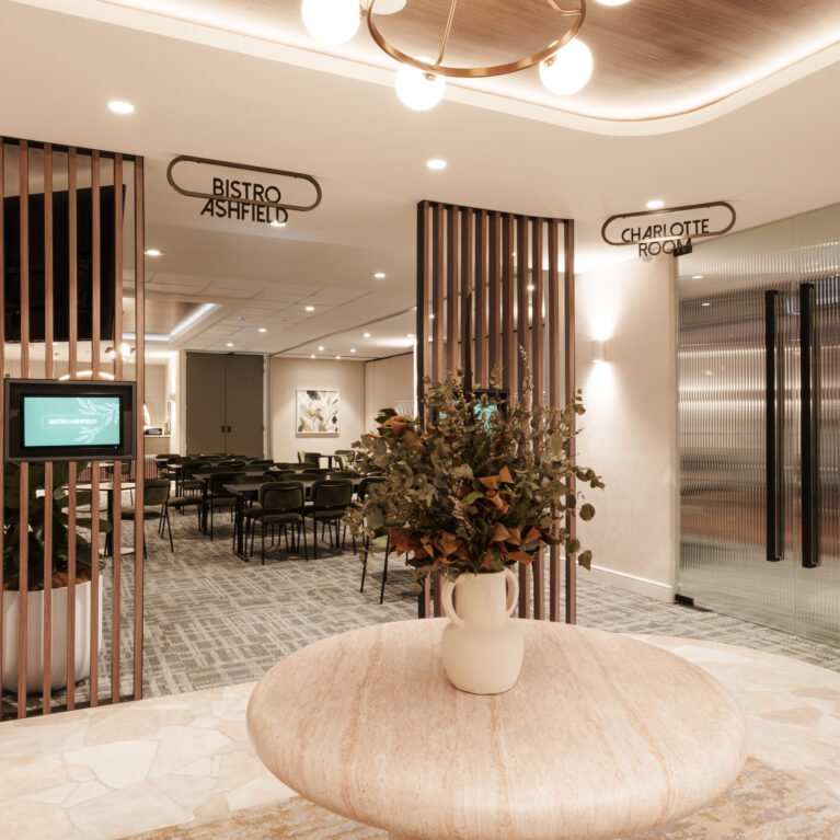 Vertical timber battens, travertine display table, reeded glass doors, crazy paving tile floor, brass ring chandelier, digital wayfinding displays, ceiling cove lighting, venue foyer, function room entry, architectural screen partition