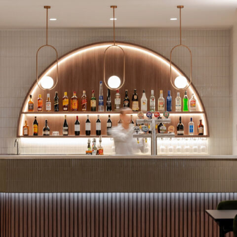 Ribbed cladding, fluted bar front, kit-kat tiles, copper accents, integrated LED lighting, arched display, warm timber veneer, hospitality fit-out, club interior design, Level 1 venue