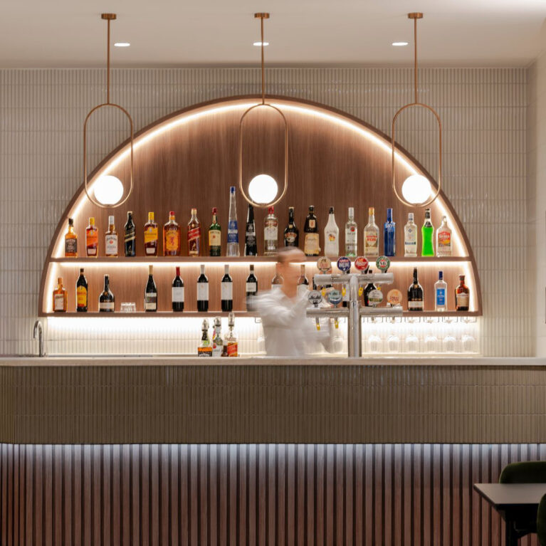 Ribbed cladding, fluted bar front, kit-kat tiles, copper accents, integrated LED lighting, arched display, warm timber veneer, hospitality fit-out, club interior design, Level 1 venue