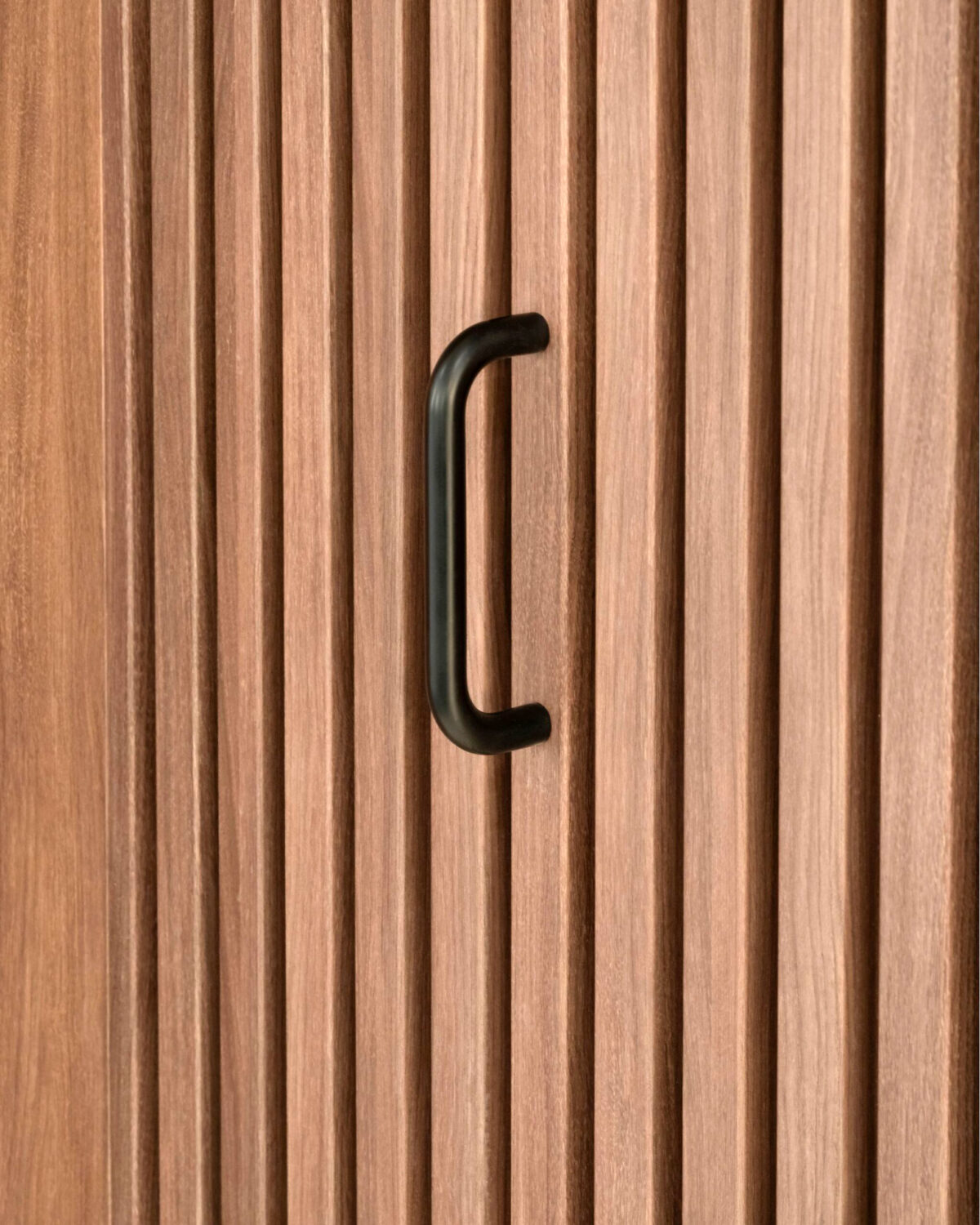 Vertical timber battens, matte black door handle, architectural joinery, concealed door integration, tactile wood cladding, custom millwork detail, commercial interior fit-out, timber wall feature