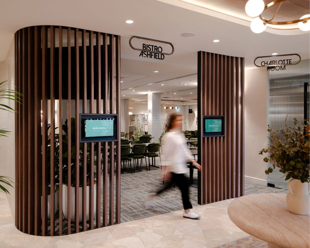 Timber batten screen, digital room displays, custom metal signage, Bistro Ashfield entrance, crazy paving floor, travertine table, commercial circulation, interior architecture, hospitality fit-out
