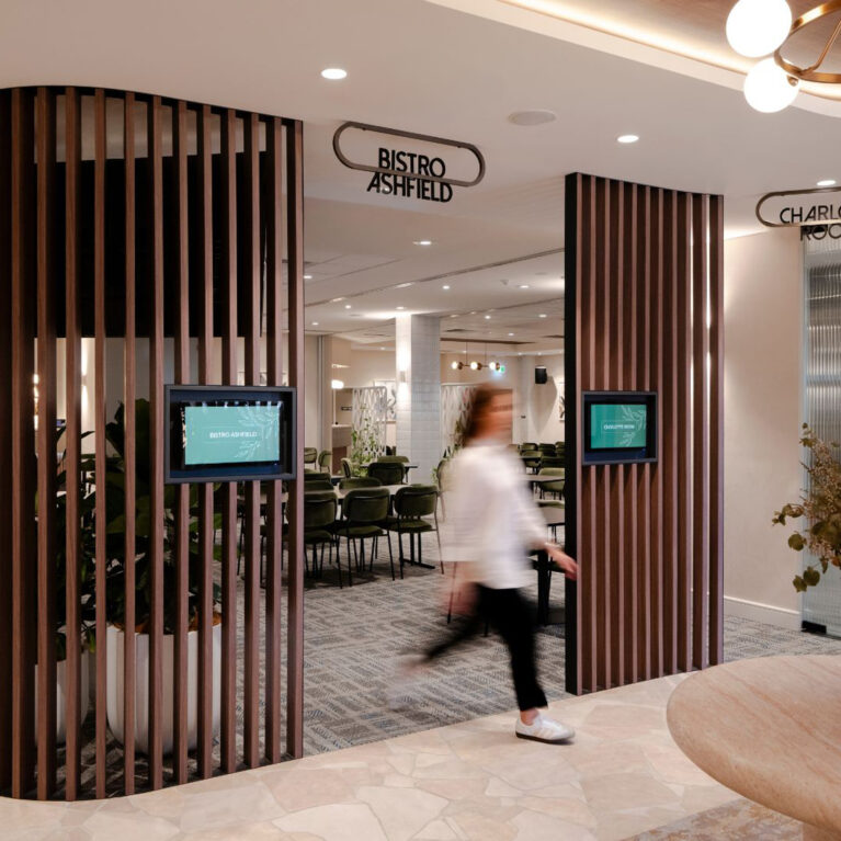 Timber batten screen, digital room displays, custom metal signage, Bistro Ashfield entrance, crazy paving floor, travertine table, commercial circulation, interior architecture, hospitality fit-out