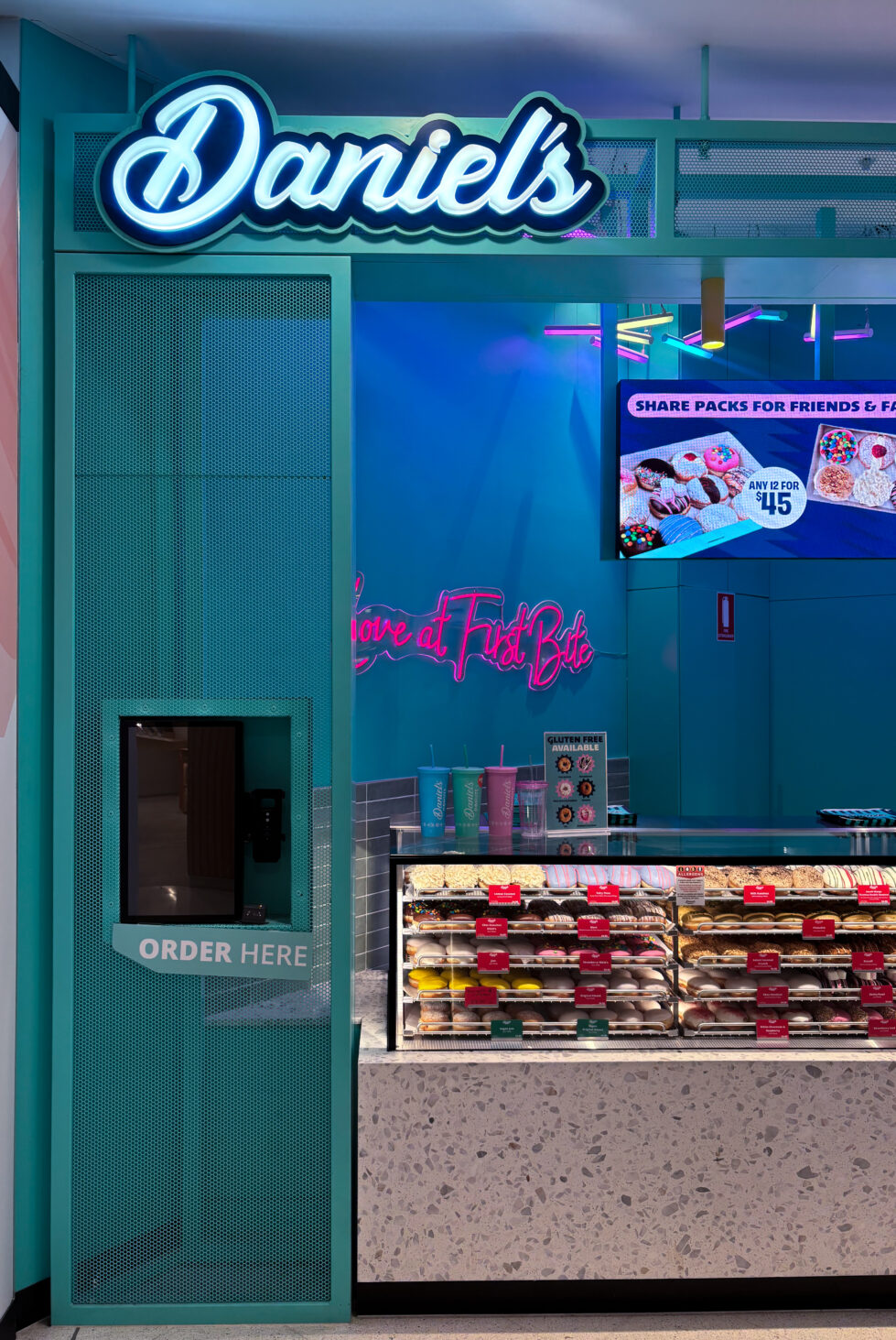 A playful, high-energy welcome to the Daniel’s Donuts experience, where the journey begins with a tap.