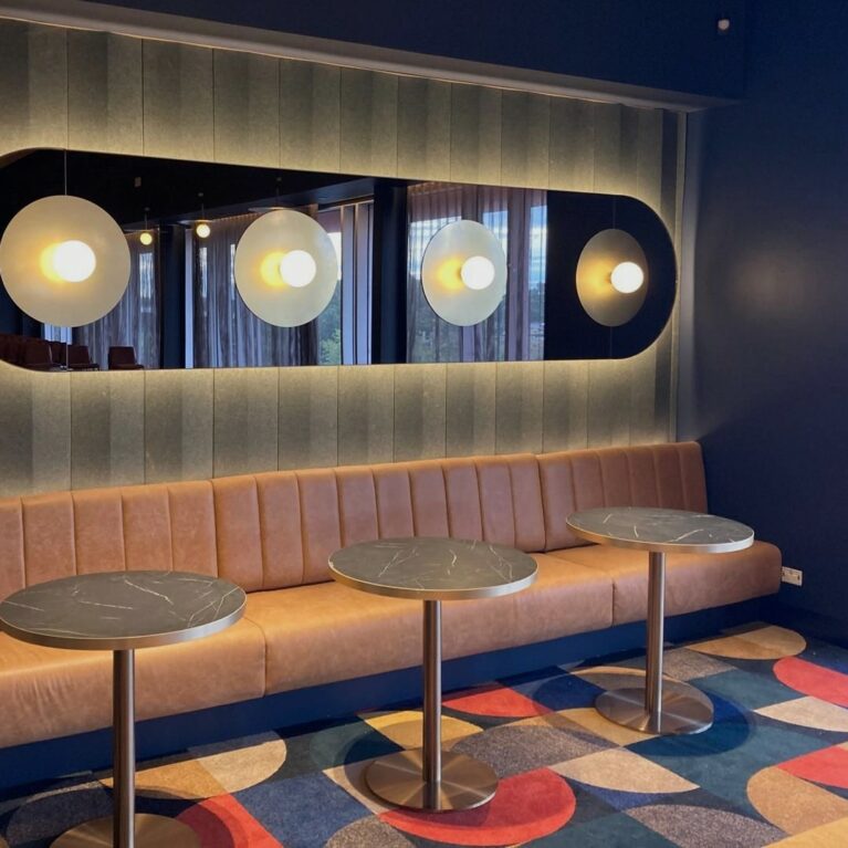 A refined lounge space where warm textures, soft lighting, and thoughtful details invite guests to relax, connect, and enjoy the pre-show atmosphere.