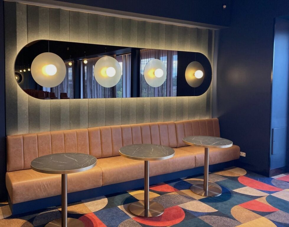 A refined lounge space where warm textures, soft lighting, and thoughtful details invite guests to relax, connect, and enjoy the pre-show atmosphere.