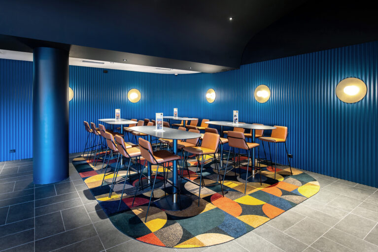 A vibrant enclave within the lounge offering elevated seating, bold colour and a lively geometric energy.