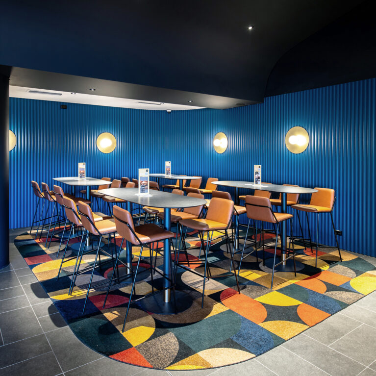 A vibrant enclave within the lounge offering elevated seating, bold colour and a lively geometric energy.
