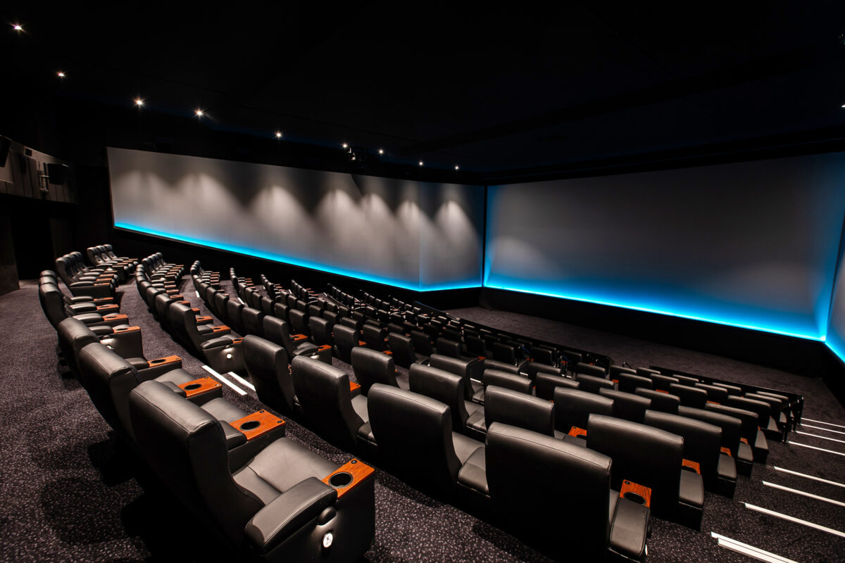 A premium large-format auditorium defined by cinematic scale and precision lighting.