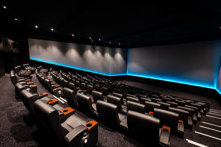 A premium large-format auditorium defined by cinematic scale and precision lighting.