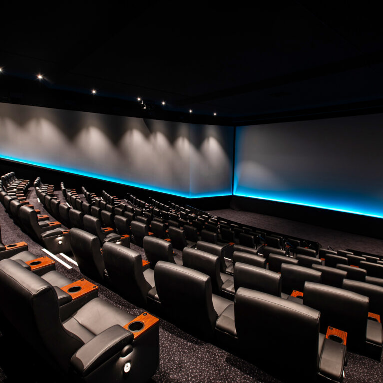 A premium large-format auditorium defined by cinematic scale and precision lighting.