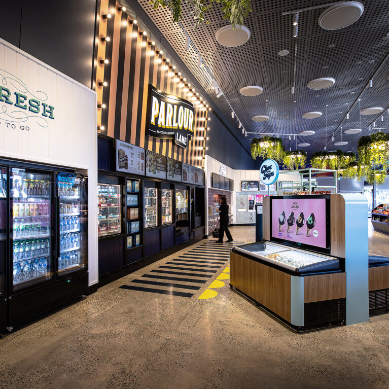 A cohesive grab-and-go and popcorn offer framed by bold branding and clear sightlines.