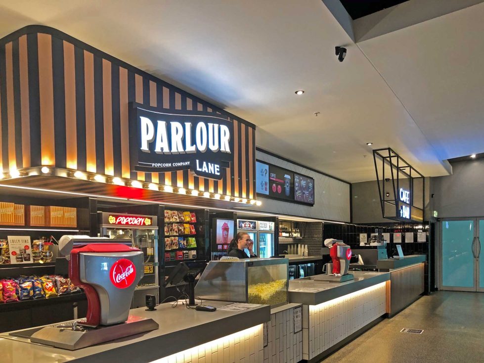 The Parlour Lane concession stand, featuring a sleek counter, ample snack options, and bold signage.