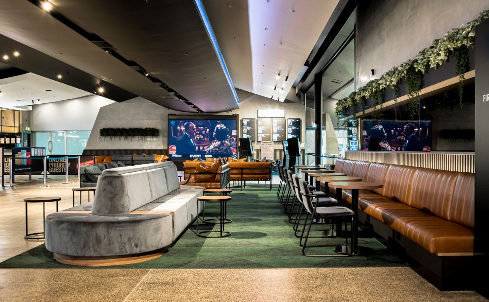 The cinema’s lobby seating area, offering a blend of curved couches, stylish tables, and modern decor for a comfortable gathering space.