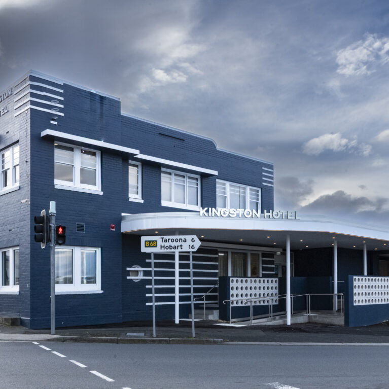 The Kingston Hotel’s historic façade holds its Art Deco bones with pride. Fresh midnight-blue brickwork, crisp white trims and subtle geometric detailing frame the venue’s new life, signalling a revitalised hospitality destination while honouring its place in the local streetscape.