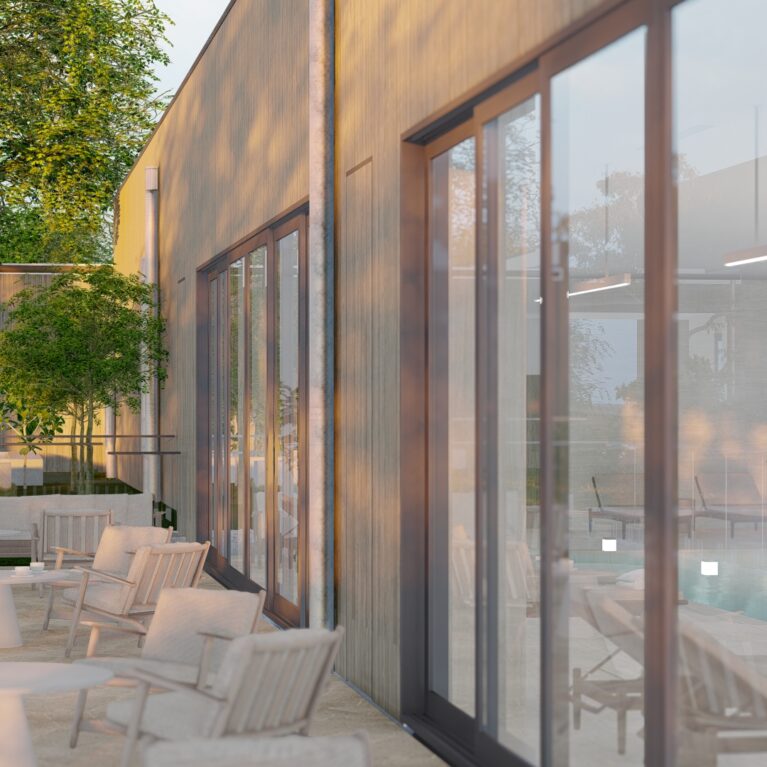 This outdoor sanctuary lounge features timber-framed seating and greenery on Torino Crazy Paving. Large glass doors connect the lounge to the indoor pool, creating a seamless transition between the tranquil outdoor space and the serene aquatic environment.