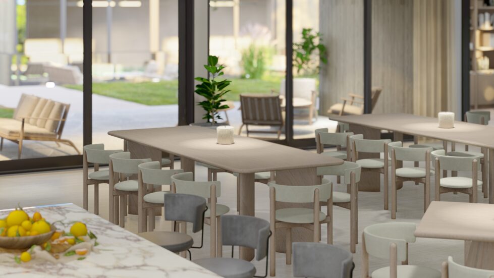 This dining area features timber tables and upholstered chairs in soft neutral tones. The Maximum Viola porcelain kitchen island anchors the space, while large glass doors open to the outdoor lounge, enhancing the connection between interior and exterior settings.