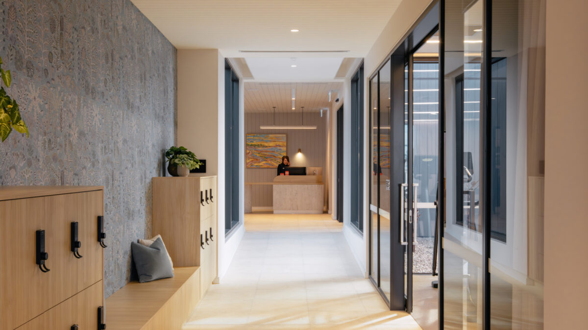 A welcoming corridor leads to concierge. Timber lockers and a long bench add usefulness; patterned walling and framed views add delight. The result: a functional, art-led arrival that still feels calm.