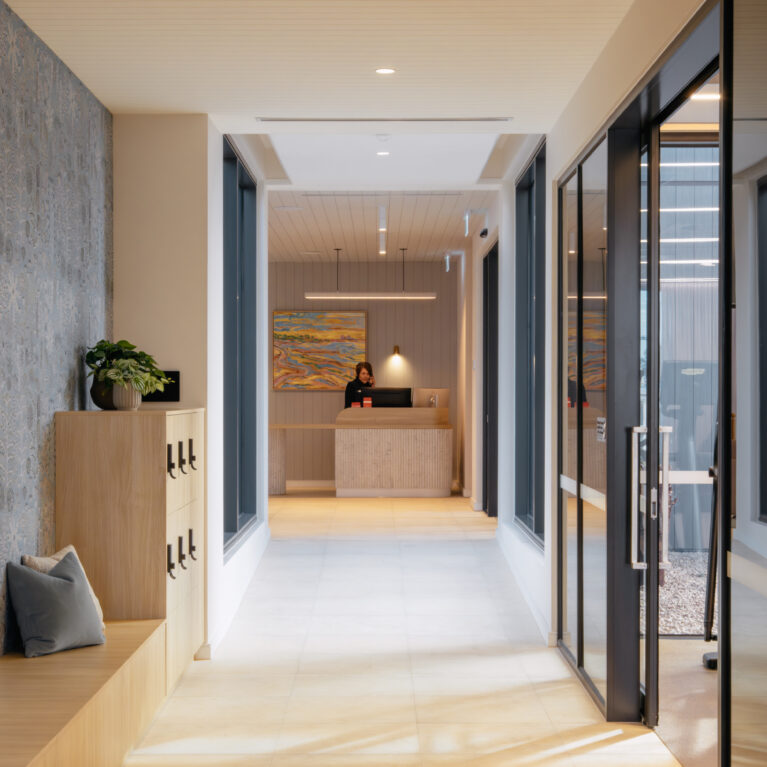 A welcoming corridor leads to concierge. Timber lockers and a long bench add usefulness; patterned walling and framed views add delight. The result: a functional, art-led arrival that still feels calm.