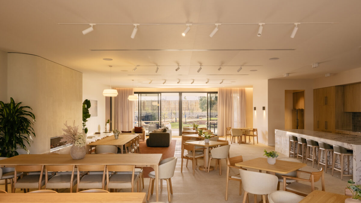 A warm, flexible “great room” where dinners, trivia nights and club meetings flow around a generous chef’s island, layered timber joinery and soft sheers to the garden terrace.