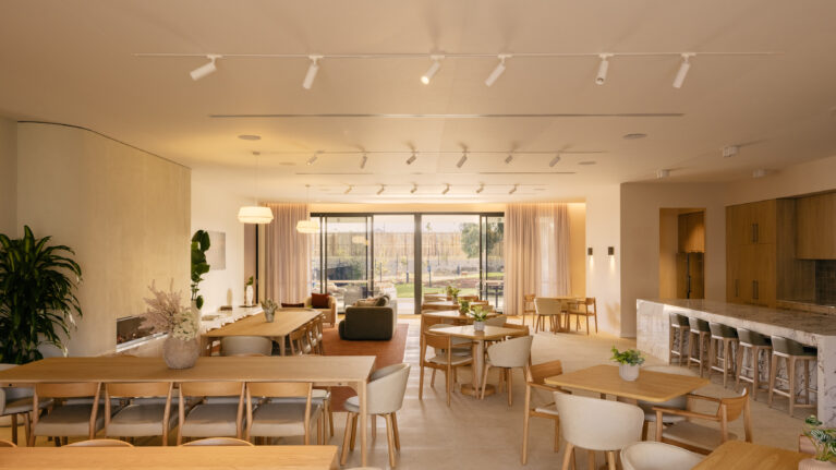A warm, flexible “great room” where dinners, trivia nights and club meetings flow around a generous chef’s island, layered timber joinery and soft sheers to the garden terrace.