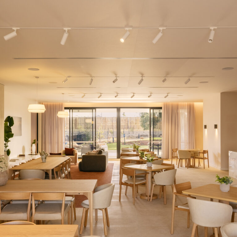 A warm, flexible “great room” where dinners, trivia nights and club meetings flow around a generous chef’s island, layered timber joinery and soft sheers to the garden terrace.