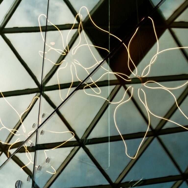 A delicate lily motif made of warm LED strips decorates the glass façade, offering a subtle nod to the salon’s name. This glowing outline provides an elegant visual marker, visible from within the mall’s open, light-filled atrium.