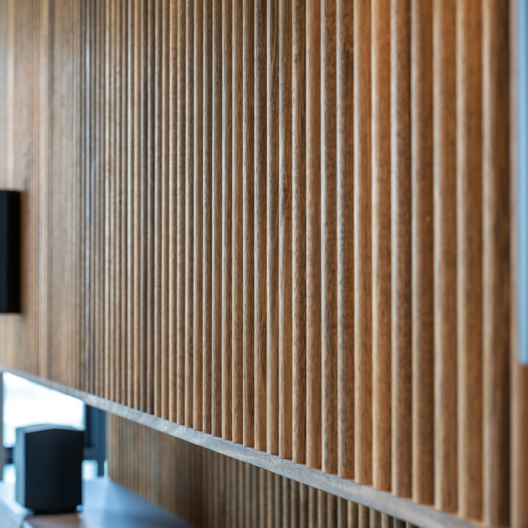 A detailed view of the master bedroom’s ribbed timber feature wall, adding warmth and texture to the space.