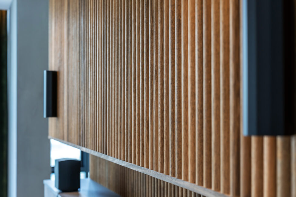 A detailed view of the master bedroom’s ribbed timber feature wall, adding warmth and texture to the space.