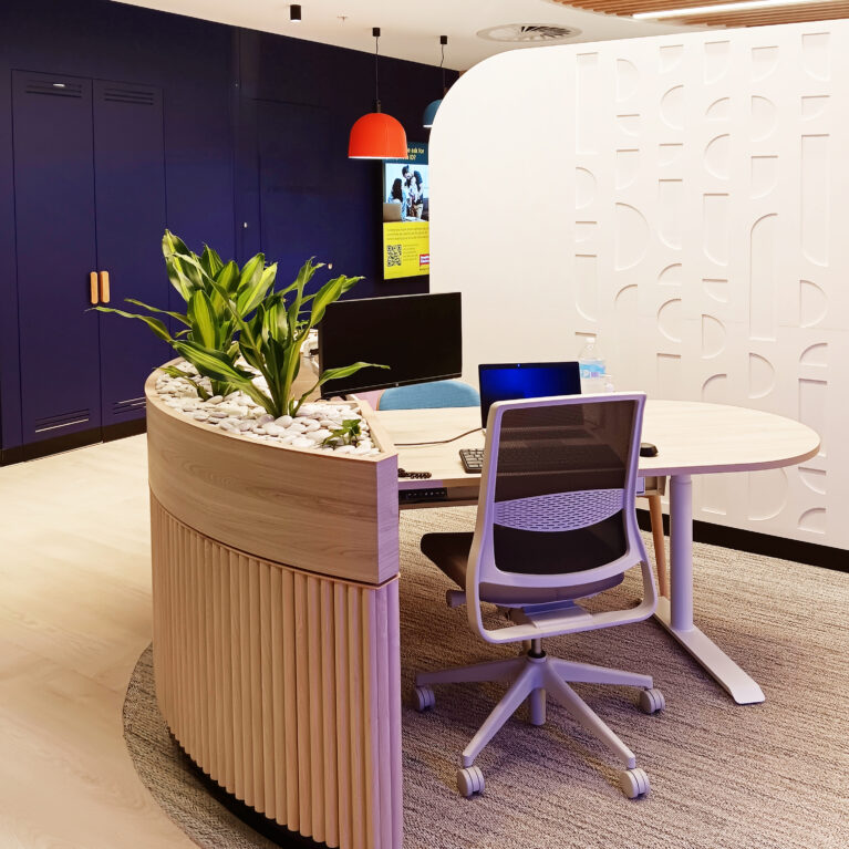 Inviting client advisory desks with a modern curved design, soft textures, and a featured leafy planter for a fresh touch.